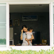 wide angle shot Asian single mother feeling exhausted after take care her daughter and cleaning home same time at tiny home domestic workers