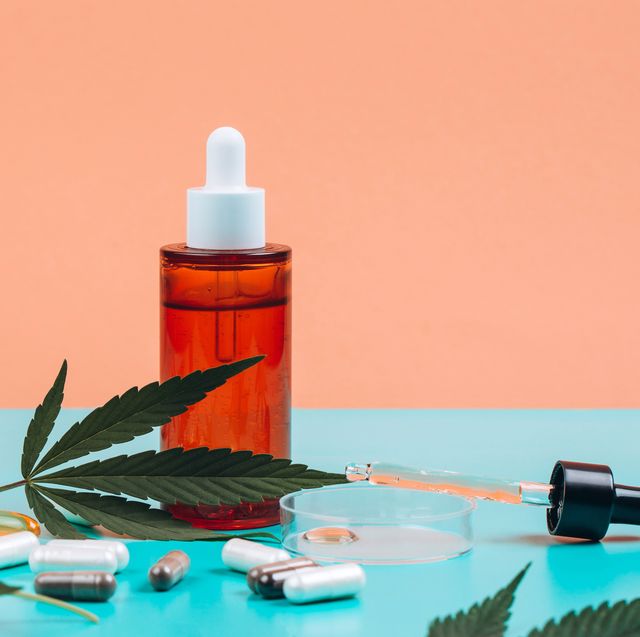 cbd oil in bottle and in pipette in petri dish near nutritional supplements made of cannabis on orange turquoise background with cannabis leaves copy space for your design front view