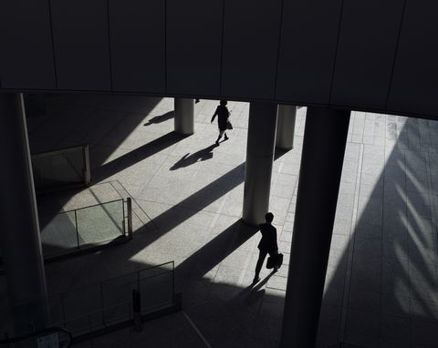 sunny morning commute with silhouettes of business people and office workers arriving at modern business district of tokyo, japan