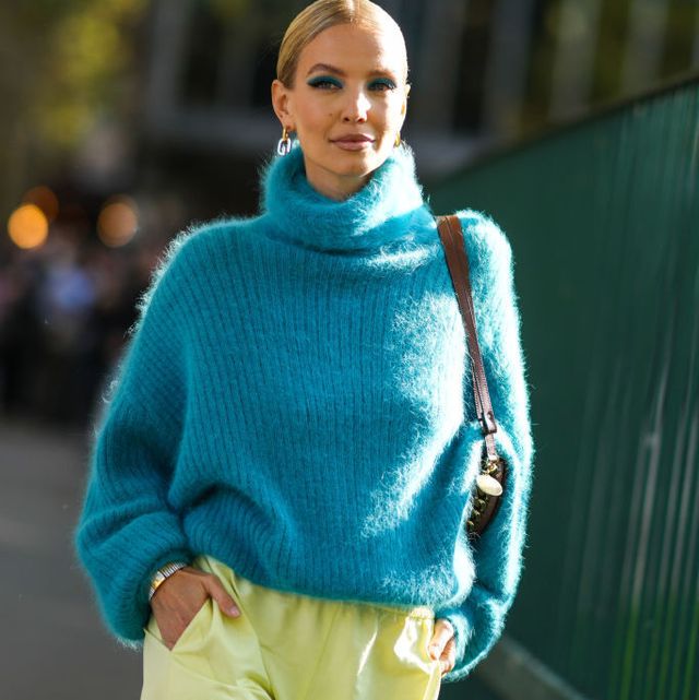 paris, france   october 04 leonie hanne wears a gold and silver large pendant earrings, a blue fluffy turtleneck oversized pullover, a brown shiny leather with a chain shoulder bag form stella mccartney, pale yellow high waist cargo pants, outside the stella mccartney show, during paris fashion week   womenswear spring summer 2022, on october 04, 2021 in paris, france photo by edward berthelotgetty images