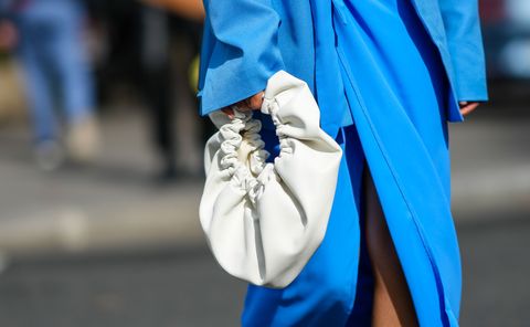 paris, france   october 02 angela gonzalez wears a blue oversized blazer jacket, a high waist matching blue slit  split flowing skirt knot on the waist, a white leather puffy handbag, white leather strappy heels sandals, outside vivienne westwood, during paris fashion week   womenswear spring summer 2022, on october 02, 2021 in paris, france photo by edward berthelotgetty images