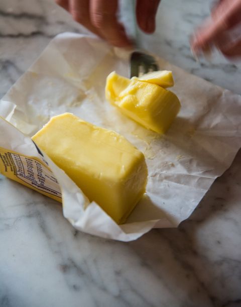 close up of a pat of butter on an open wrapper one of the ingredients in the preparation of homemade apple strüdel, a traditional dessert from south tyrol, made with layered pastry dough filled with apples and raisins, on a marble table in a domestic kitchen in italy