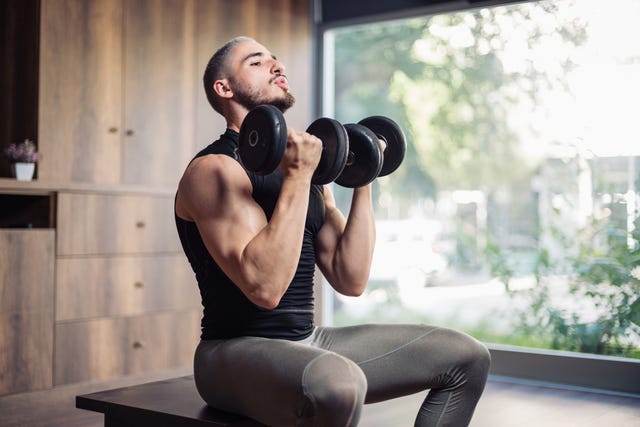 muscular athletic young man training for body building at home