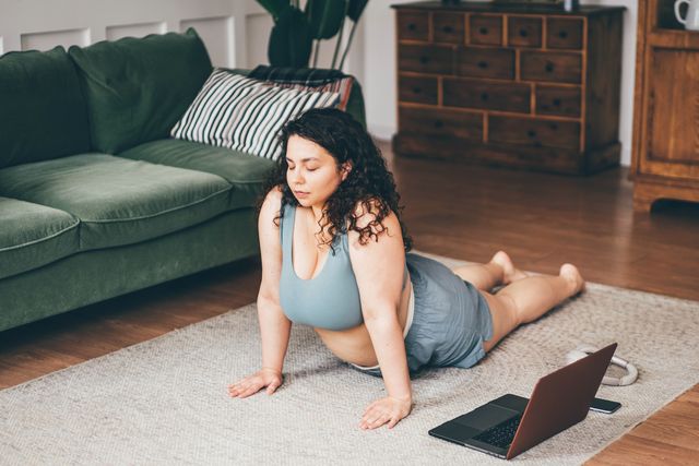 dikke vrouw doet thuis yoga