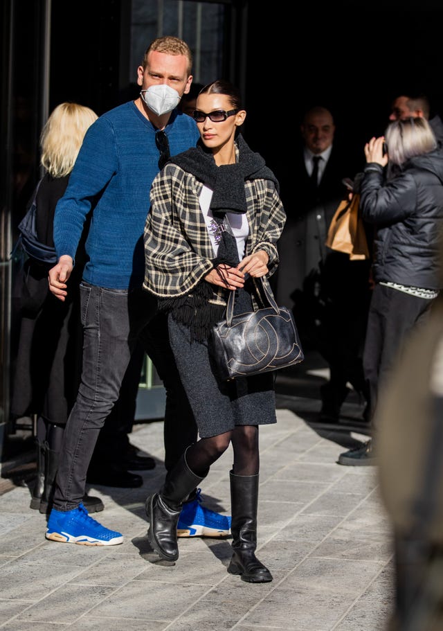 milan, italy february 24 model bella hadid is seen wearing chanel bag, checkered scarf, grey skirt, sheer tights, knee high boots in black outside max mara fashion show during the milan fashion week fallwinter 20222023 on february 24, 2022 in milan, italy photo by christian vieriggetty images