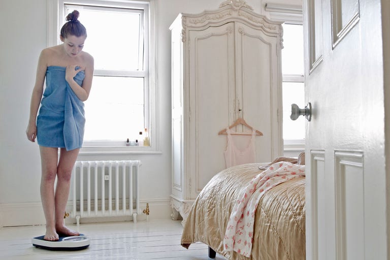 Woman weighing herself at home Woman weighing herself at home