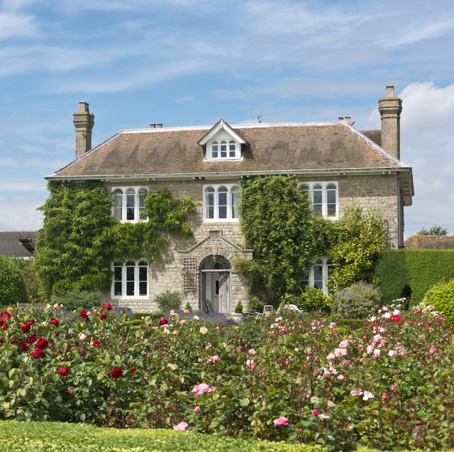 a picturesque english country cottage with rose garden, located in an english village