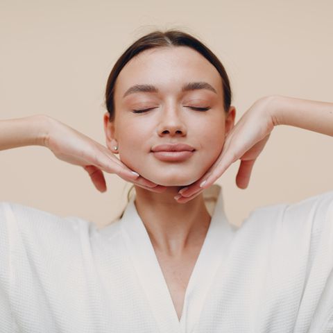 young woman doing face building facial gymnastics self massage