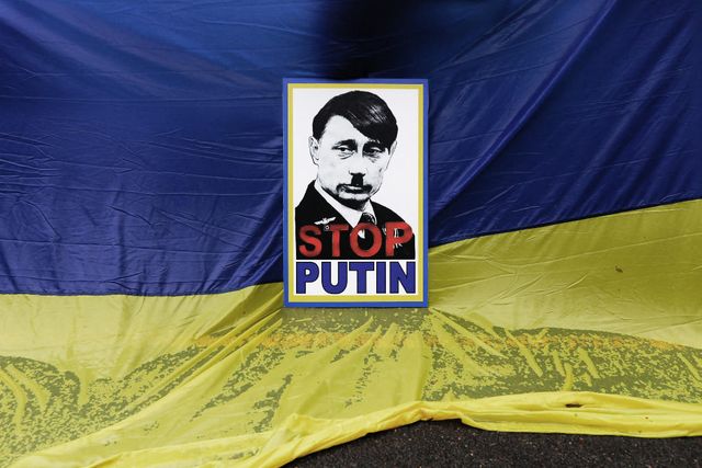a member of south africa's ukrainian association holds a poster depicting russian president vladimir putin as adolf hitler during a protest in support of ukraine in front of the russian embassy in pretoria, on february 25, 2022 photo by phill magakoe  afp photo by phill magakoeafp via getty images