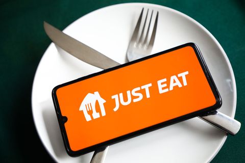 just eat app logo is displayed on a mobile phone screen photographed for illustration on a plate and with cutlery krakow, poland on february 9, 2021 numbers show that the covid 19 pandemic resulted  in a significant increase of meals ordered online through food delivery apps and websites photo illustration by beata zawrzelnurphoto via getty images