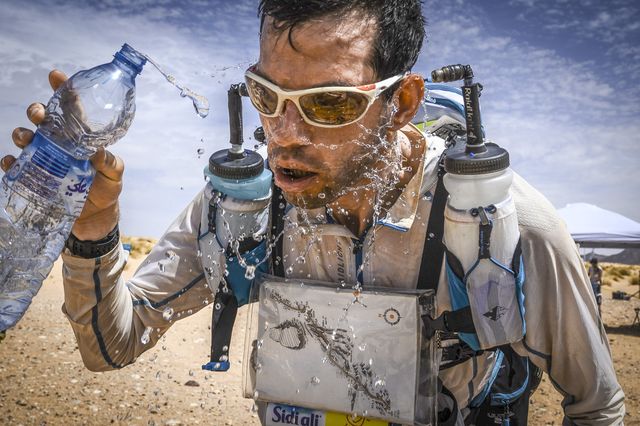 corredor exhausto bebe agua en el marathon des sables de 2019
