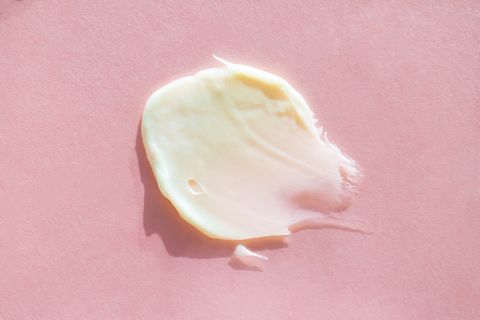 smear of pastel beige body cream on light pink background concept of natural skin care cosmetic extreme close up and flat lay style