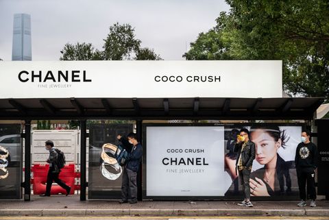 hong kong, china   20220206 commuters wait at a bus stop covered with french multinational clothing and beauty products brand chanel advertisement in hong kong photo by budrul chukrutsopa imageslightrocket via getty images