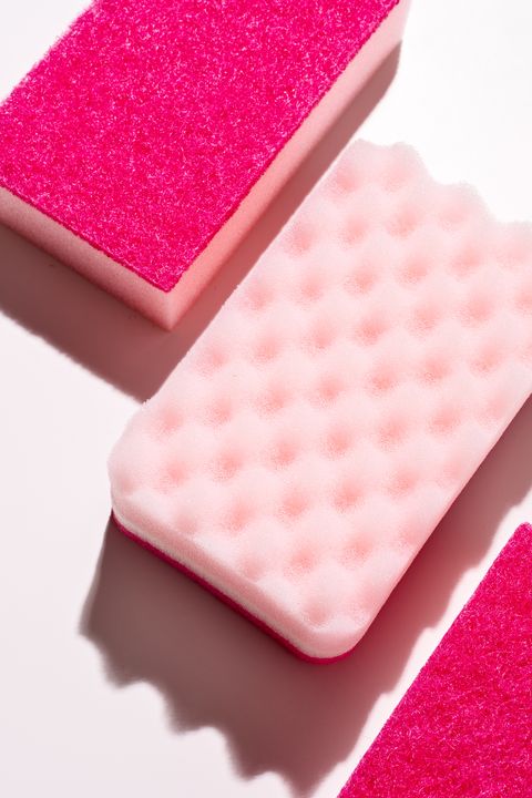 pink cleaning sponges on pink background close up view