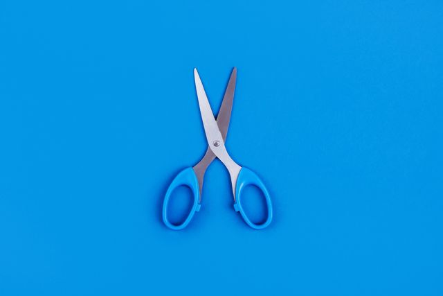 small blue scissors on a blue background with a place around