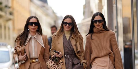 milan, italy   february 21 l r a guest wears sunglasses, earrings, a brown jacket, a brown shirt, a belt, pants, black shoes  a guest wears a brown trench long coat, a gray jacket  a guest wears sunglasses, an oversized wool turtleneck woven pullover, a salmon pink skirt, quilted sandals, outside sportmax, during milan fashion week fallwinter 2020 2021 on february 21, 2020 in milan, italy photo by edward berthelotgetty images