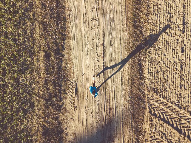 drone view on woman running on autumn field at late afternoon