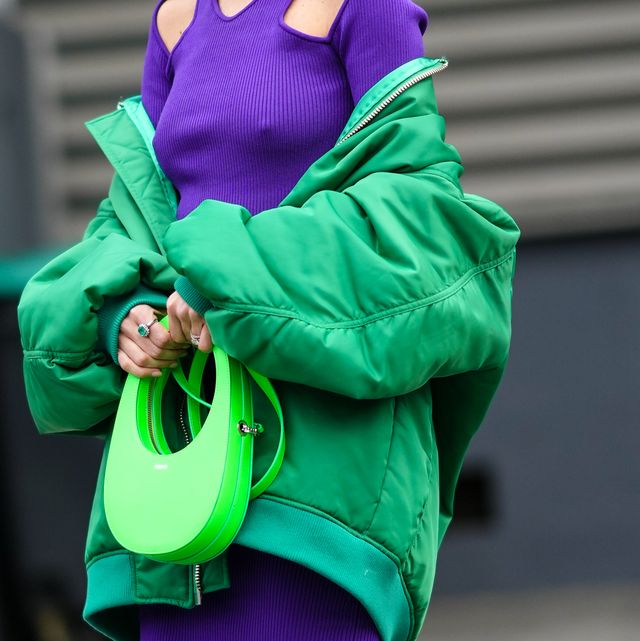 paris, france   march 03 alexandra pereira wears silver and gold earrings, a neon purple turtleneck  cut out chest and shoulder  long sleeveless  tube midi dress, a green oversized bomber coat, a neon green shiny leather handbag from coperni, silver and diamonds rings, outside coperni, during paris fashion week   womenswear fw 2022 2023, on march 03, 2022 in paris, france photo by edward berthelotgetty images