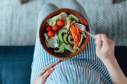 cropped shot of pregnant woman eating vegetarian salad having healthy diet during pregnancy