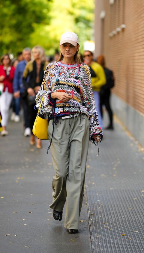 een gast draagt trui met gaten tijdens milan fashion week