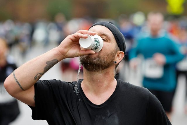 boston, ma november 13 a runner gets a drink as he passes a water station during the boston half marathon on november 13, 2022 in boston, massachusetts photo by winslow townsongetty images