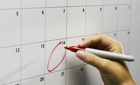 Woman circling day on wall calendar, close-up