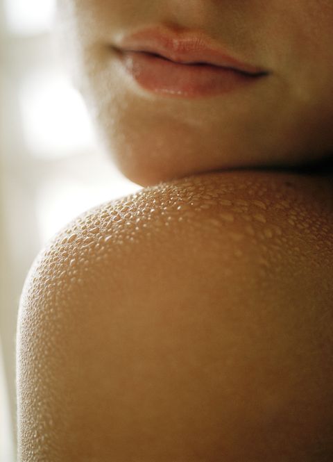 Young woman's shoulder covered in water, close up