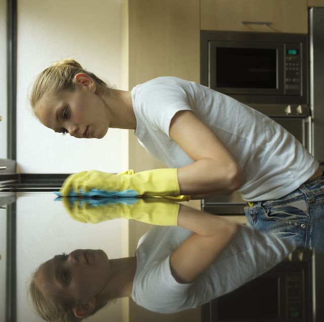 Young woman cleaning kitchen worktop