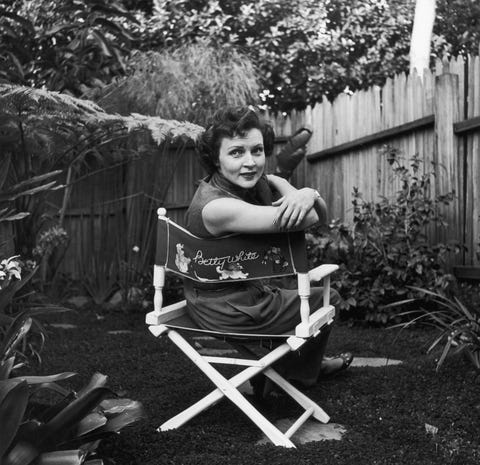 circa 1956  american actor betty white sits in a canvas chair with her name written on the back, looking over her shoulder in a backyard garden  photo by hulton archivegetty images