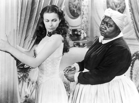 1939 british actor vivien leigh 1913 1967 holds on to a pillar as american actor hattie mcdaniel 1895 1952 tightens her corset in a still from the film, 'gone with the wind,' directed by victor fleming photo by mgm studiosgetty images