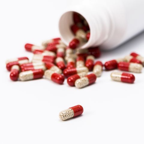 Many red and transparent medical capsules, filled with