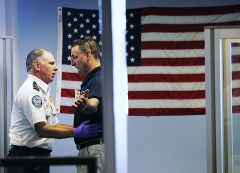 A man is checked by a Transportation Security Administration officer before boarding a flight at Por