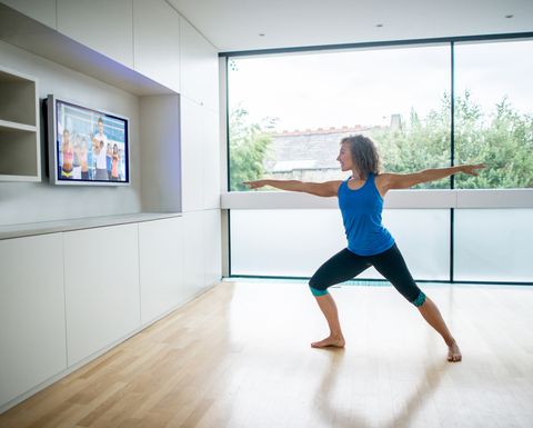 Woman exercising at home watching a Pilates DVD