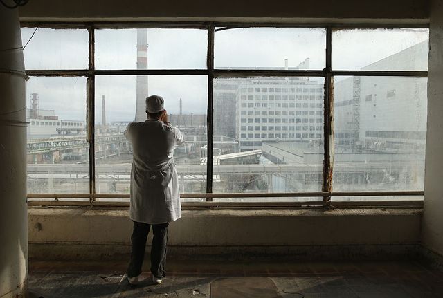 chornobyl, ukraine   september 29  a visitor touring the former chernobyl nuclear power plant takes a photo through a window looking towards facilities that house reactors one and two on september 29, 2015 near chornobyl, ukraine the chernobyl plant is currently undergoing a decades long decommissioning process of reactors one, two and three, which continued operation for years following the accident at reactor four on april 26, 1986, technicians at chernobyl conducting a test inadvertently caused reactor number four, which contained over 200 tons of uranium, to explode, flipping the 1,200 ton lid of the reactor into the air and sending plumes of highly radioactive particles and debris into the atmosphere in a deadly cloud that reached as far as western europe 32 people, many of them firemen sent to extinguish the blaze, died within days of the accident, and estimates vary from 4,000 to 200,000 deaths since then that can be attributed to illnesses resulting from chernobyls radioactive contamination today large portions of the inner and outer chernobyl exclusion zone that together cover 2,600 square kilometers remain contaminated a consortium of western companies is building a movable enclosure called the new safe confinement that will cover the reactor remains and its fragile sarcophagus in order to prevent further contamination  photo by sean gallupgetty images