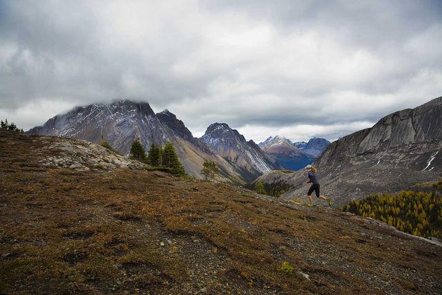 a woman enjoys a rainy day run in the rocky mountains of alberta, canada