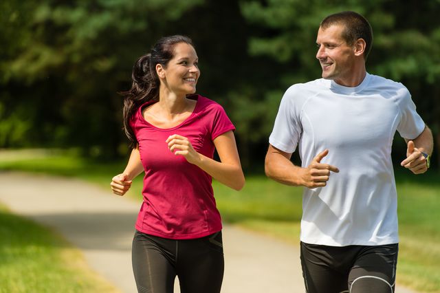 portrait of cheerful caucasian couple running outdoors