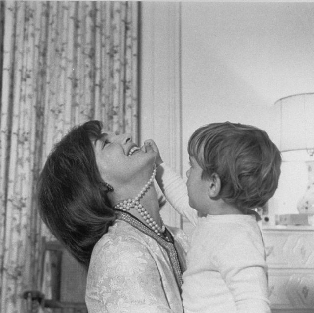 first lady jacqueline kennedy smiling w her head thrown back as son, john f kennedy, jr, plays with the string of simulated pearls around her neck at the white house  photo by cecil stoughtonthe life images collection via getty imagesgetty images