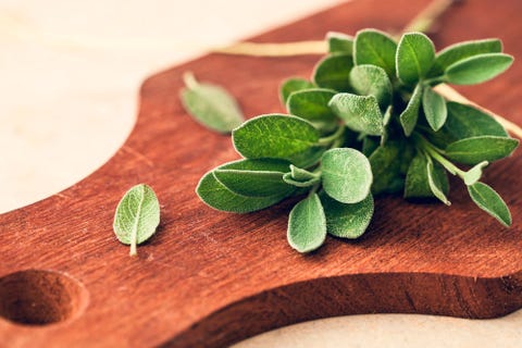 fresh organic sage leaves over a wood cutting board