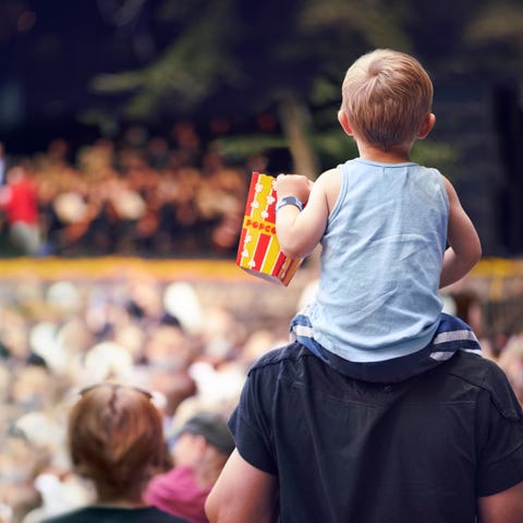 young boy sitting on his fathers shoulders at an outdoor festival young boy sitting on his fathers shoulders at an outdoor festival