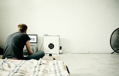 Caucasian man using laptop in bedroom