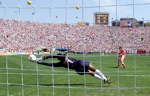 pasadena,   us goalkeeper briana scurry l lunges as she stops the penalty kick by liu ying of the chinese soccer team in a shoot out at the end of their game in the finals of the womens world cup at the rose bowl in pasadena, california 10 july 1999  the us team scored all of their five penalty shots to win the game electronic image afp photohector mata photo credit should read hector mataafp via getty images