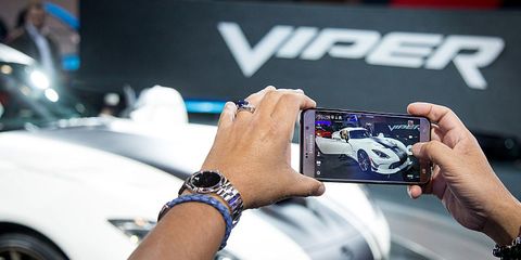 an attendee uses a mobile device to photograph the fiat chrysler automobiles nv dodge viper acr vehicle during the 2016 new york international auto show nyias in new york, us, on tuesday, march 29, 2016 tweets, posts and snaps help auto shows reach millions of consumers beyond those that go to the annual events to sit in cars and dream about what could go in their driveways photographer michael naglebloomberg via getty images