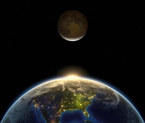 the sun and the moon appearing over the earth the dark side of the earth shows the city and night lights