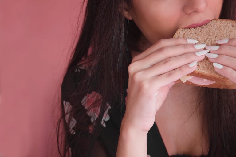 A Young Woman Eating A Sandwich.