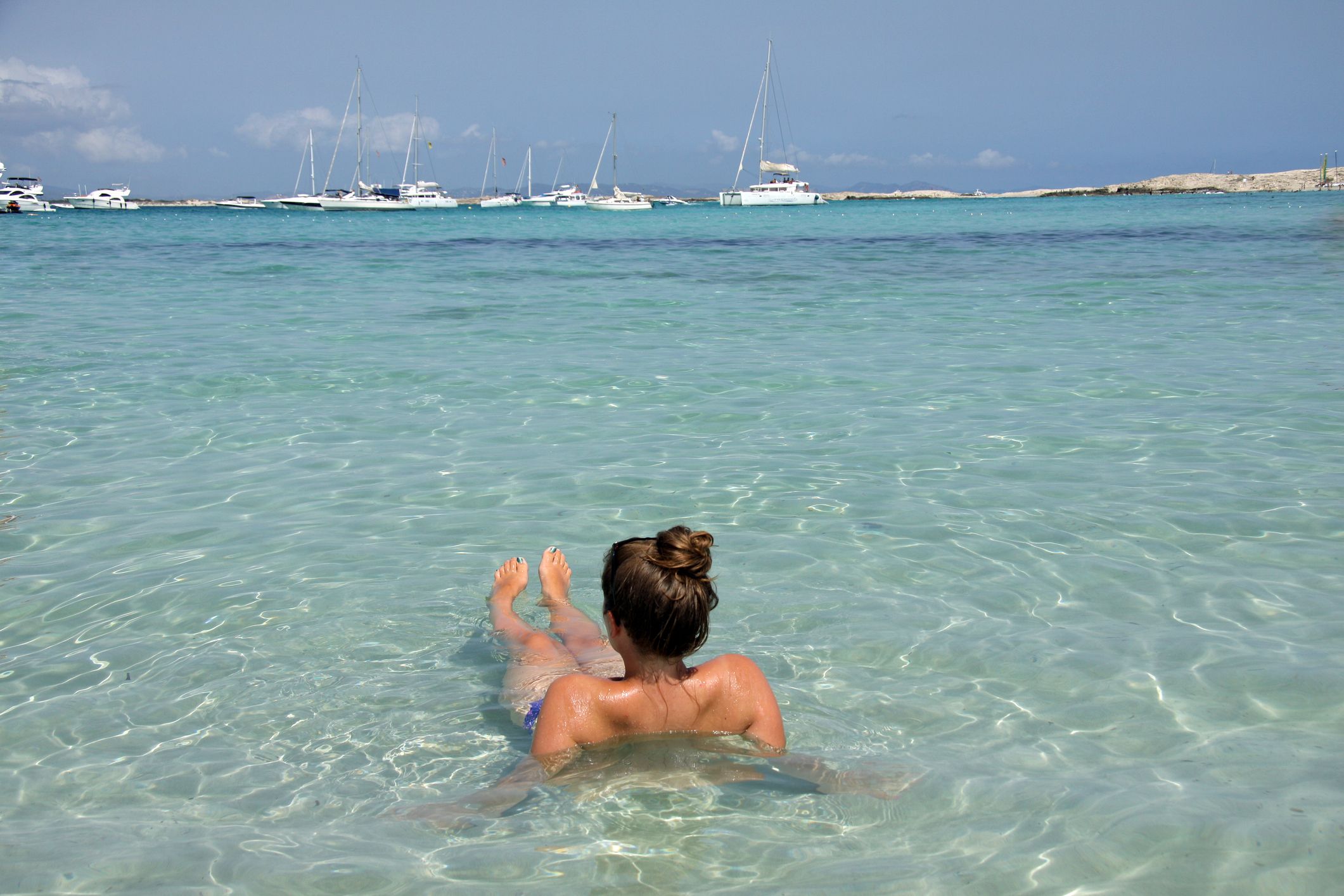 Topless ladies surrounded by dressed men at the beach