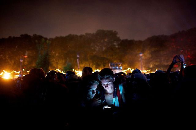 brothers check a smartphone while waiting front row for calvin harris to perform during performs at the budweiser made in america music festival in philadelphia, pa on september 1, 2013 photo by mark makelacorbis via getty images