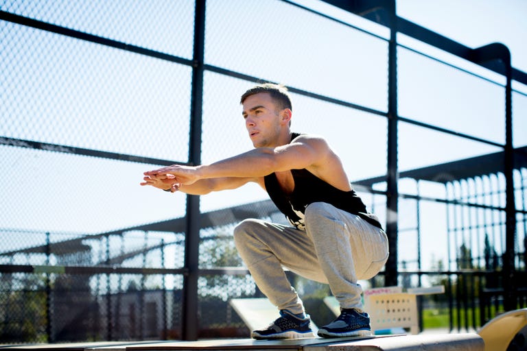 Young man squatting outdoors