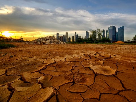 Singapore skyline at sunset and cracked earth