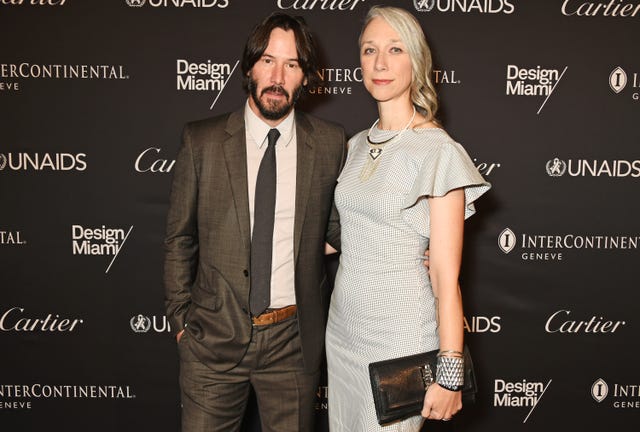 Keanu Reeves et Alexandra Grant posent pour les caméras sur le tapis rouge.