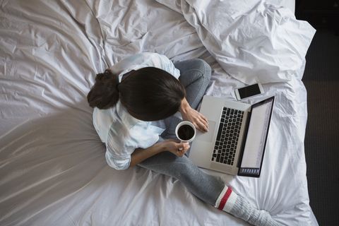 Overhead view of woman with coffee at laptop